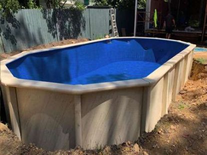 A new, high-quality replacement pool liner being installed in an oval pool.