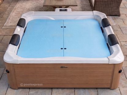Pool Express - A square hot tub with a light brown wood-style exterior, four black headrests, and an Insulating Spa Cover in light blue, situated on a stone patio.